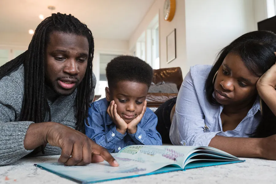 Dad and mom reading to child.